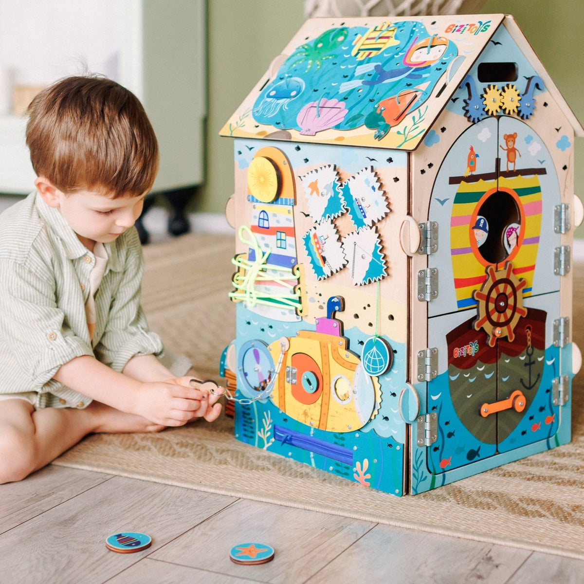 Chłopiec bawi się tablicą manipulacyjną Busy House Pirate — zabawki montessori - 6