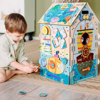 Chłopiec bawi się tablicą manipulacyjną Busy House Pirate — zabawki montessori