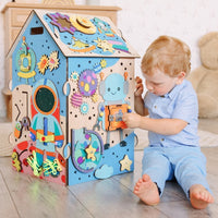 Dziecko odkrywa tablicę manipulacyjną Busy House Space — zabawka montessori od 1 roku
